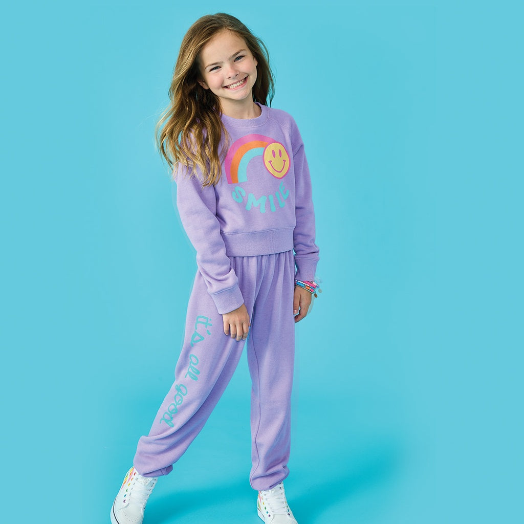 Brighten up any day with the Rainbow Smile Vivid Violet Basic Crew Neck Sweatshirt! This fun and vibrant sweatshirt is perfect for young teen girls who love to bring on the good vibes. Made with a soft blend of polyester, cotton, and rayon, it&