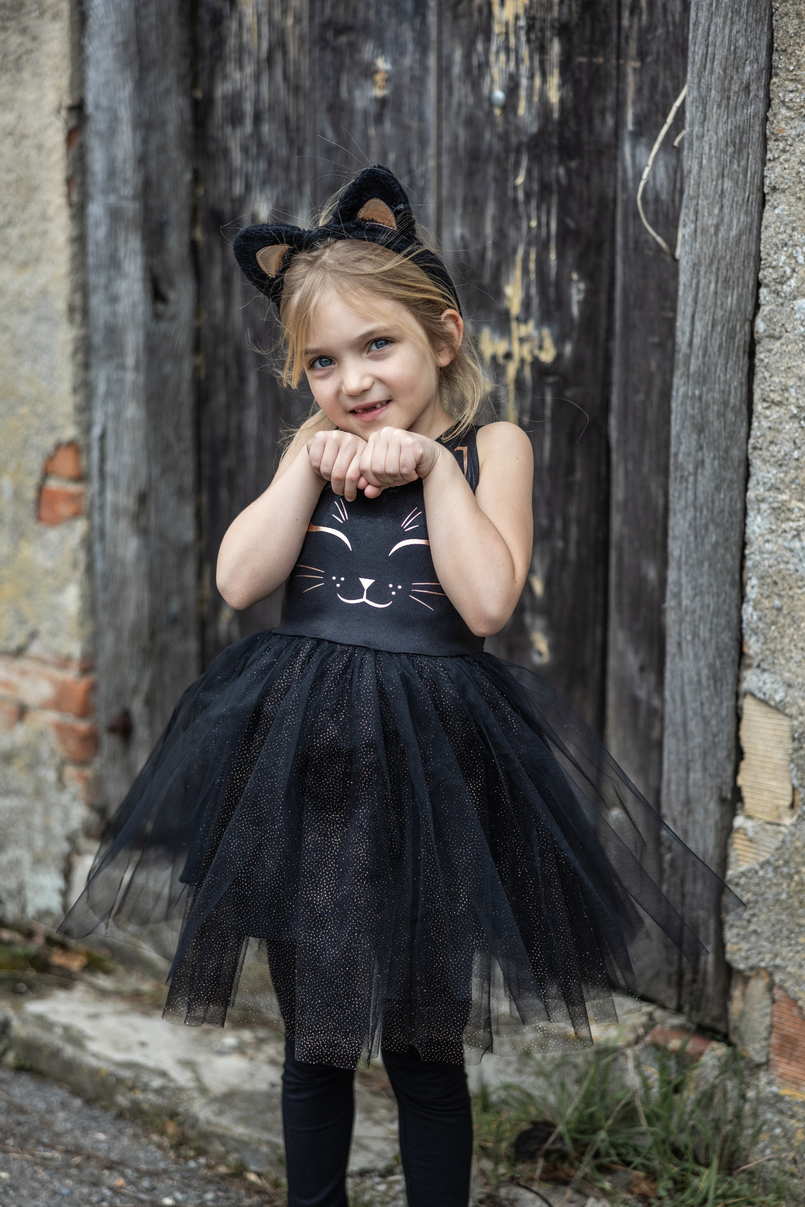 Our new Black Cat Dress & Headband is the purrfect ensemble for your little feline aficionado! The dress features a sleek black design adorned with a charming cat face printed in shimmering rose gold on the chest. Its skirt dazzles with golden heat-sealed sparkles, adding a touch of glamour to every twirl. And what&