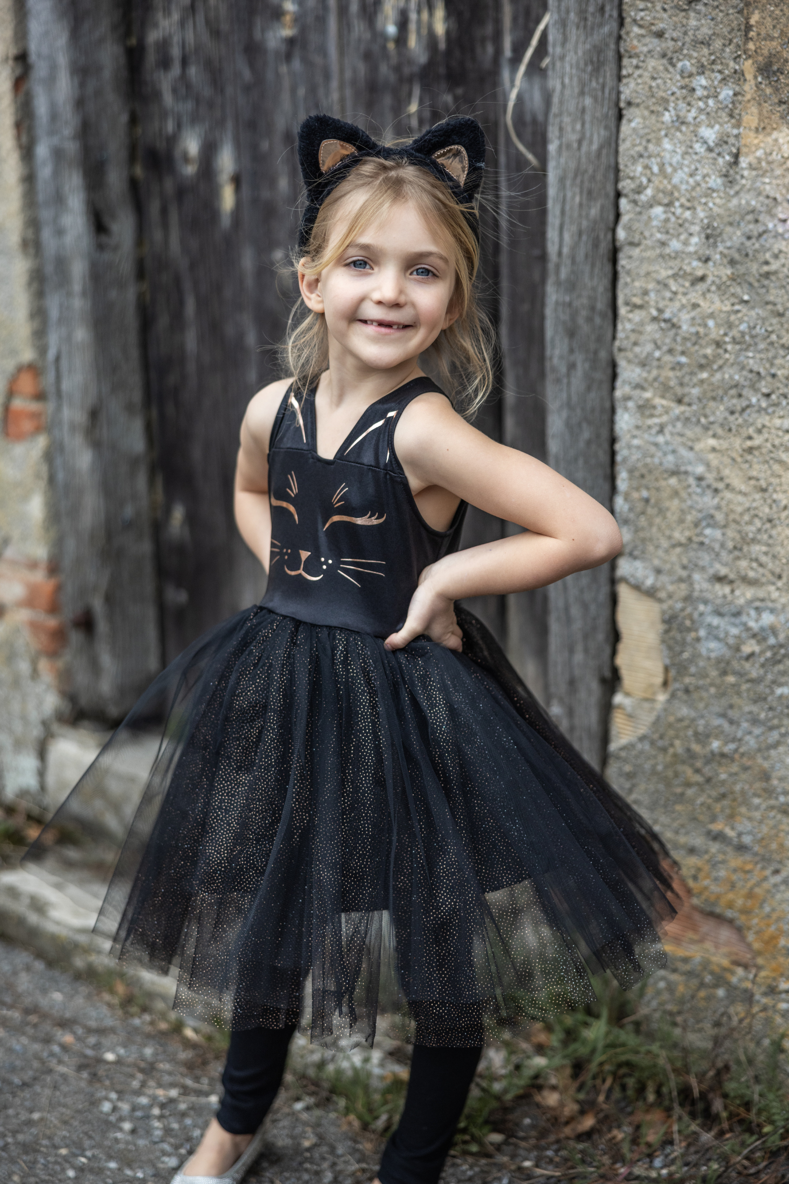 Our new Black Cat Dress &amp; Headband is the purrfect ensemble for your little feline aficionado! The dress features a sleek black design adorned with a charming cat face printed in shimmering rose gold on the chest. Its skirt dazzles with golden heat-sealed sparkles, adding a touch of glamour to every twirl. And what&