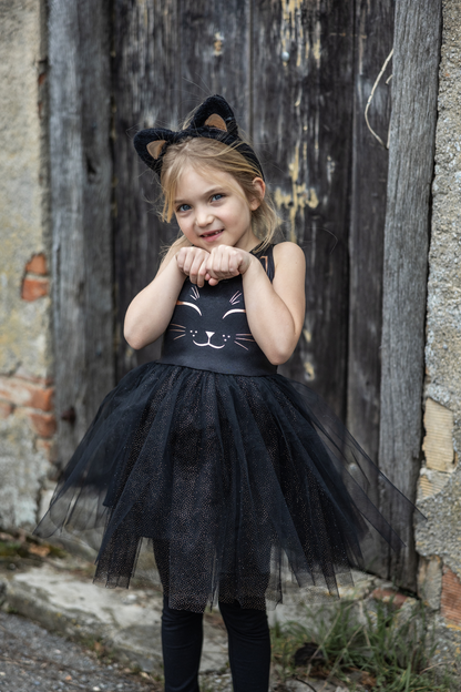 Our new Black Cat Dress &amp; Headband is the purrfect ensemble for your little feline aficionado! The dress features a sleek black design adorned with a charming cat face printed in shimmering rose gold on the chest. Its skirt dazzles with golden heat-sealed sparkles, adding a touch of glamour to every twirl. And what&