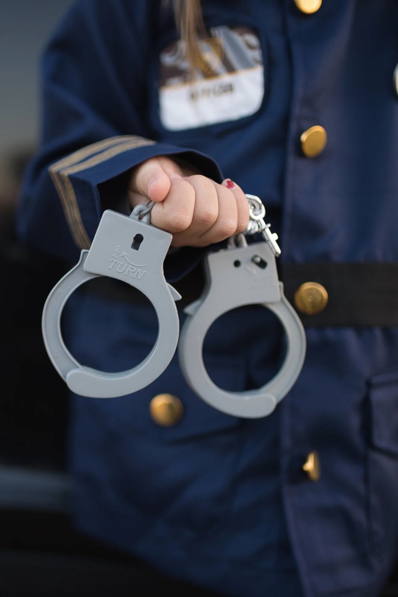 Police officer set includes: Jacket, Hat, Handcuffs, Walkie Talkie, Badge, and Name Badge.