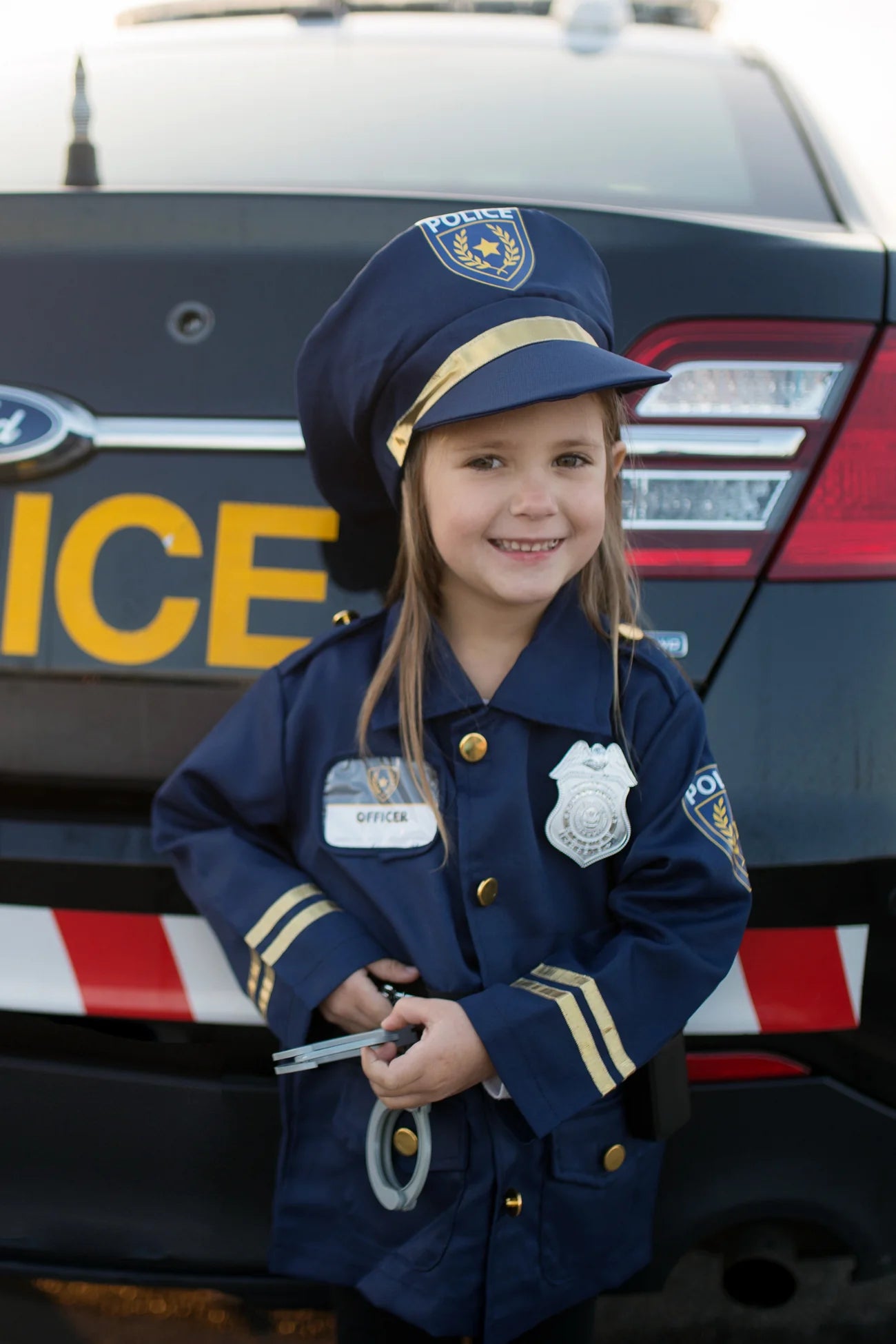 Police officer set includes: Jacket, Hat, Handcuffs, Walkie Talkie, Badge, and Name Badge.